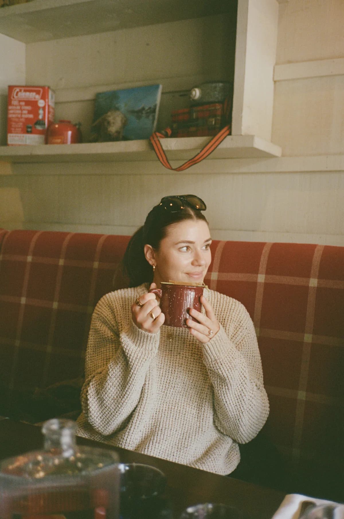 Adrianna seated with a warm drink